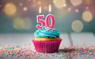 Birthday cupcake with burning lit candle with number 50.
