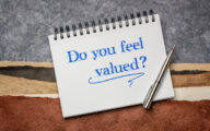 A note pad with 'do you feel valued?' written on the front