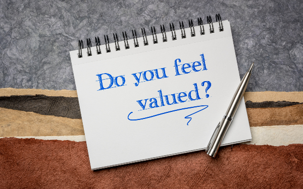 A note pad with 'do you feel valued?' written on the front
