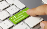 A person's forefinger pushing a green computer key with the words 'CPD continuing professional development' written on it