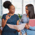 A social worker talking to a younger colleague to symboilse mentoring, coaching or practice education