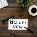 Register Now sign on a desk