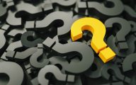Yellow question mark amid pile of black ones