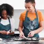 Children's home worker and staff member baking together