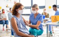 Woman receiving Covid-19 vaccine from nurse