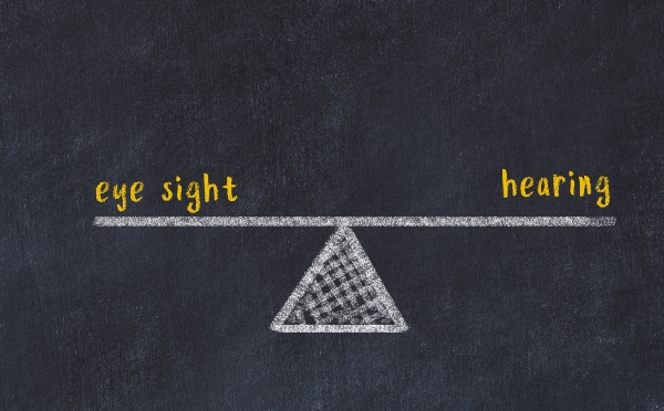 Chalk board sketch of scales. Concept of balance between eye sight and hearing