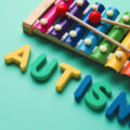 Word AUTISM and xylophone on color background