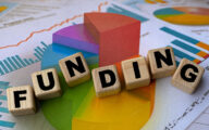 The word 'funding' spelt out in blocks against the background of some graphs