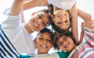 Group of four children hugging each other