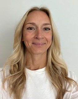 Sophie Baker sporting blonde hair and a smile, wearing a white top