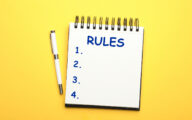 Notebook with list of rules and pen on yellow background, flat lay