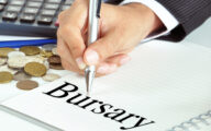 Hand with pen pointing to Bursary word on the paper - financial concept