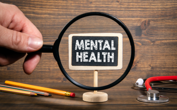Mental Health. Stress, tension, relationships and work environment concept. Man's hand, holding magnifying glass