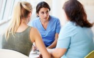 Nurse Meeting With Teenage Girl And Mother In Hospital