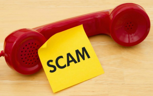 phone with post-it note saying scam
