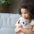 Sad girl hugging a teddy