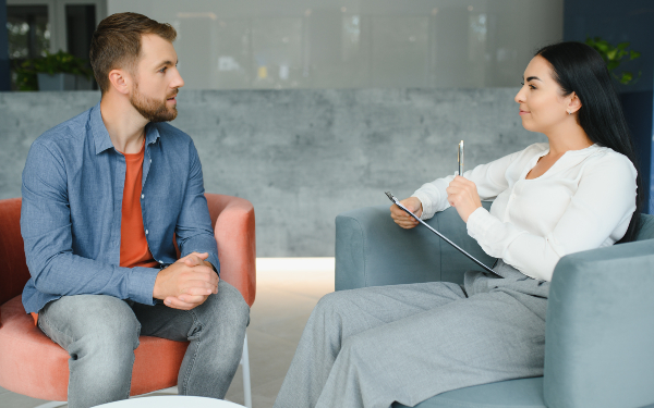 Social worker assessing/conducting therapeutic intervention with man
