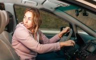 Social worker looking worried in her car