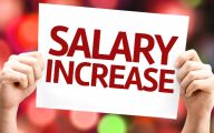 Man holding up a sign which reads 'salary increase'