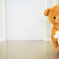 teddy bears peering out from behind a door
