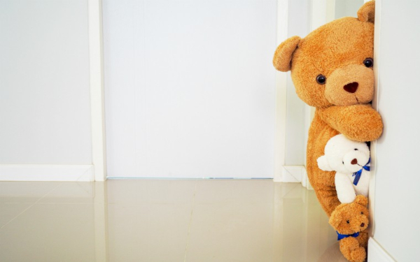teddy bears peering out from behind a door