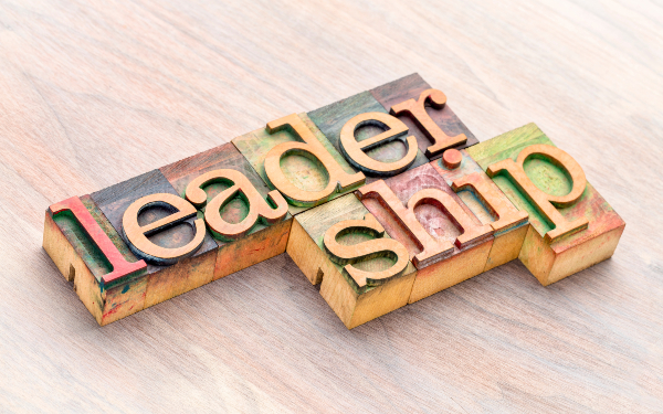 The word 'leadership' spelt out on a wooden letterpress sat on a table
