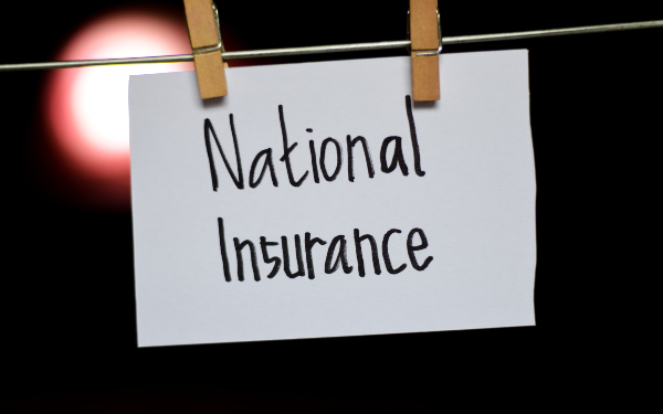 The words 'national insurance' written on a piece of paper pegged to a clothes line