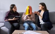 Two professionals in discussion regarding a young woman
