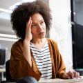 Overworked and frustrated young business woman in front of computer in office