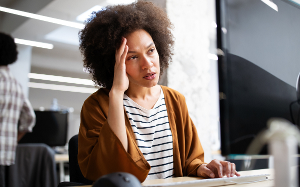 Overworked and frustrated young business woman in front of computer in office