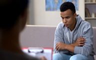 Young man looking sad talking to professional
