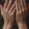 A woman covering her face with her hands.