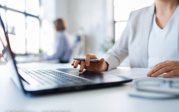 Woman's hands typing on a laptop