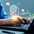 A person typing on their laptop with various holographic symbols depicting artificial intelligence
