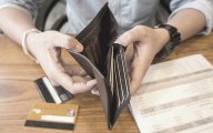 Person holding empty wallet to symbolise cost of living crisis